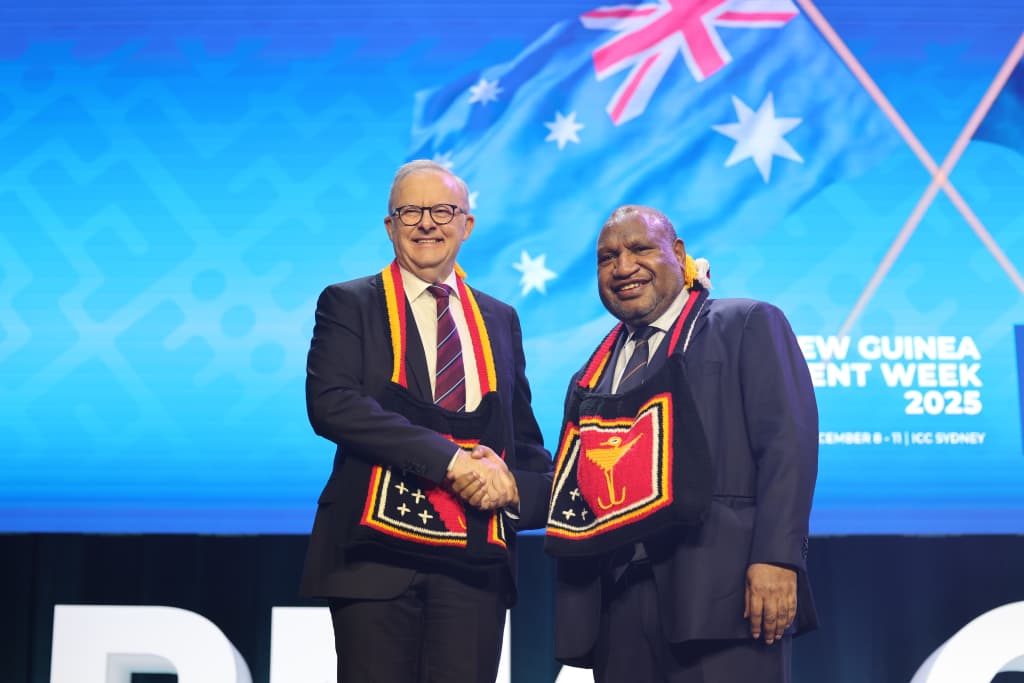 Two delegates shake hands at Papua New Guinea Investment Week 2025.